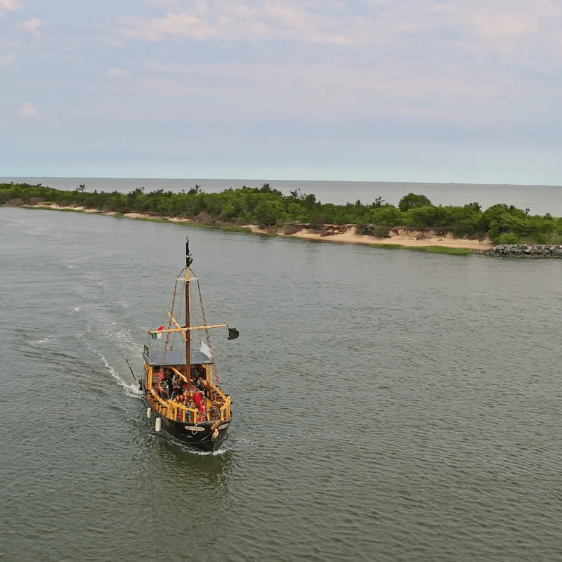a boat floating along a river next to a body of water